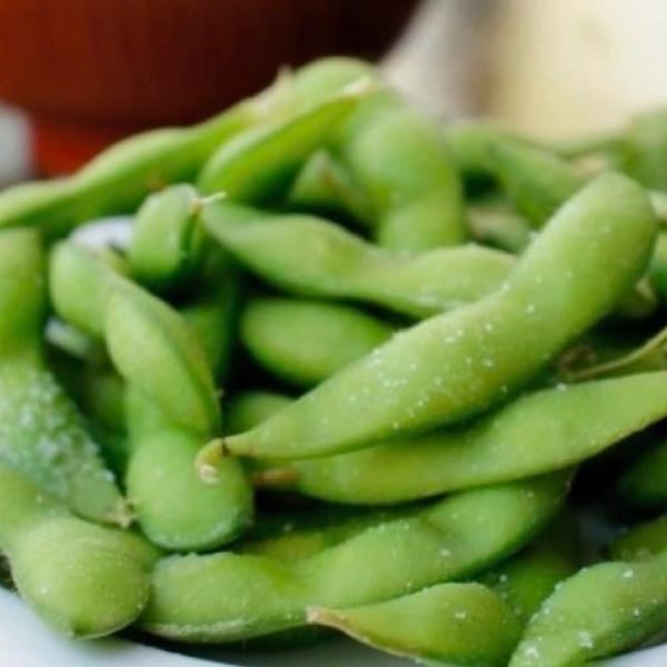 Close-up of a pile of salted edamame pods, a popular appetizer at Rice Bowl Cafe.